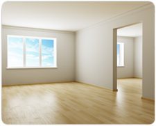 Strak gestucte lege kamer met houten vloer en daglicht door twee ramen